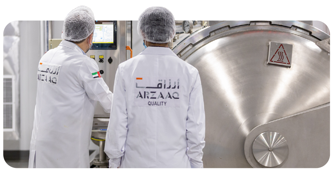 Technician managing steam-jacketed cooking kettles discharging prepared food batches